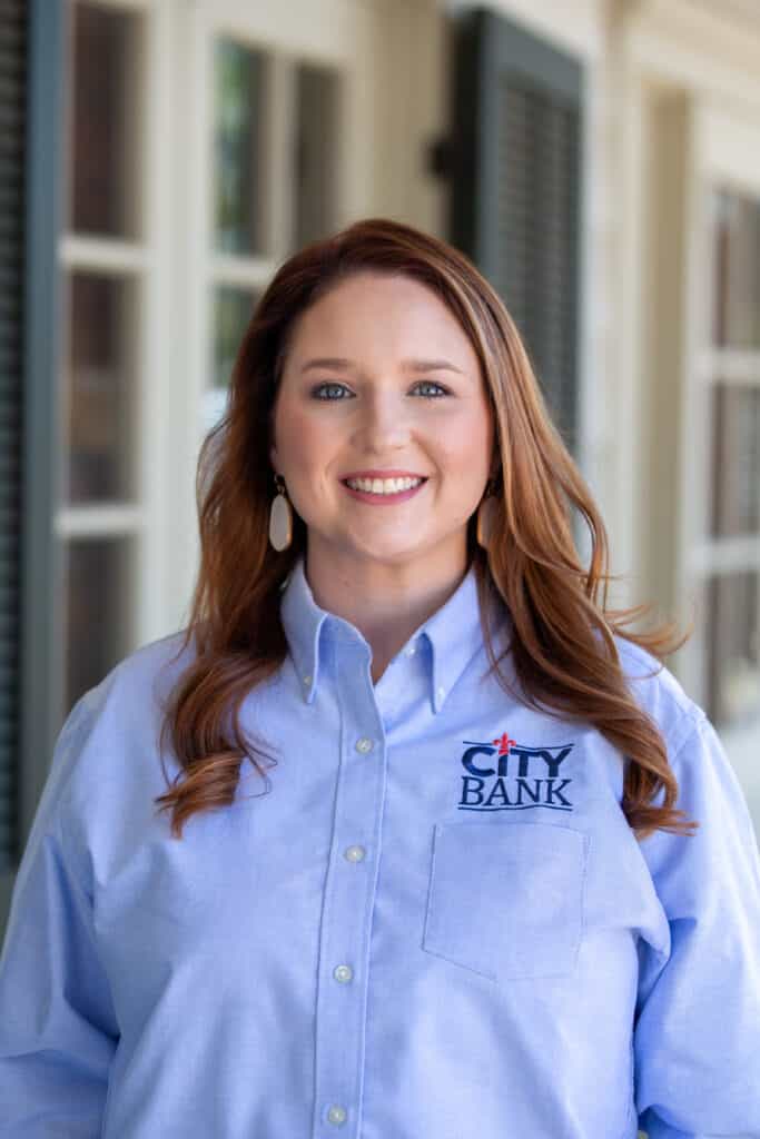 woman with red hair and a blue city bank shirt